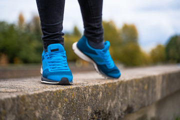 Blue sneakers on a woman legs. Outside workout in running shoes concept