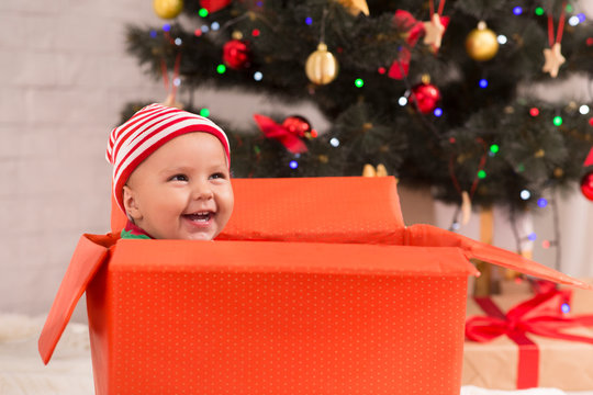 Adorable baby laughing in big Christmas gift box