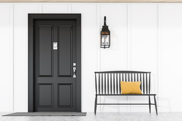 Black front door of white house with bench