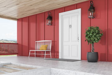 White door of red house, tree, bench, side view