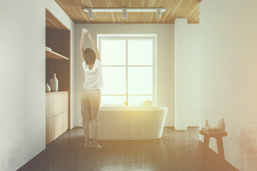 Woman in white bathroom with cabinet