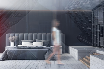 Woman walking in black bedroom with wardrobe