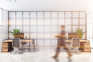 Businessman walking in white and metal office