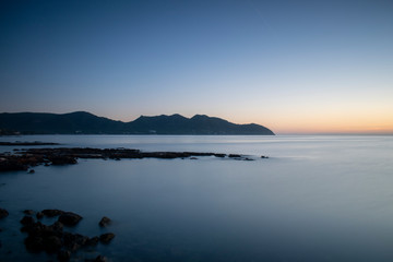 Sunrise near Cala Bona Mallorca with a flat sea giving a surreal and enigmatic feel to the early morning.