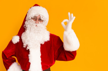 Cheerful Santa Claus with white beard showing ok sign