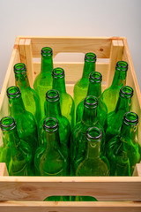 Empty wine bottles in a wooden box on the table. Home winemaking.