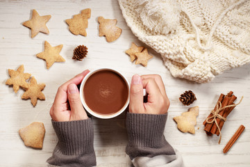 Man’s hands holding hot chocolate in white cup