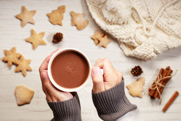 Man’s hands holding hot chocolate in white cup