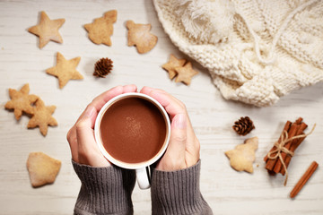 Man’s hands holding hot chocolate in white cup