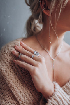 a girl in a beige jacket shows rings on her hands