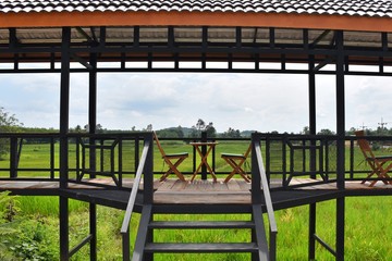Fototapeta premium table and chair set on a wooden floor with a background of green fields mountains and blue skies