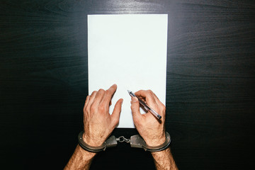 Men's hands in handcuffs. Plea agreement