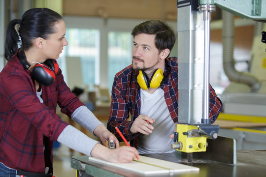 female carpentry apprentice using machinery