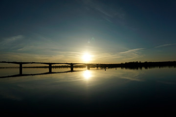 Fototapeta na wymiar Long bridge over a wide river in the morning