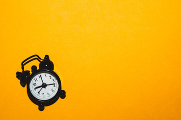 Classic alarm clock on yellow background. vintage watch with round dial