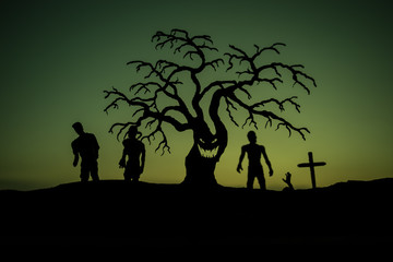 Silhouette some zombies on the cemetery walking around at sunset. Selective focus