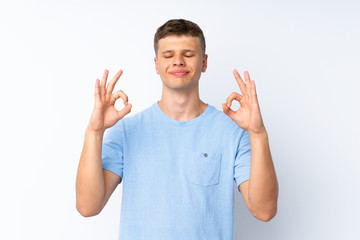 Young handsome man over isolated white background in zen pose