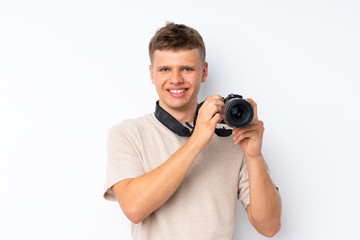 Fototapeta premium Young handsome man over isolated white background with a professional camera