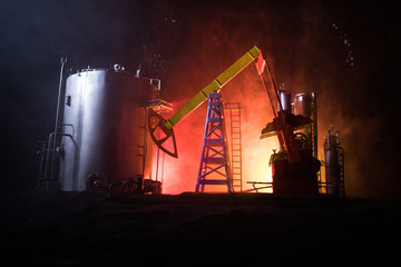 Artwork decoration. Oil pump and oil rig energy industrial machines for petroleum at night with fog and backlight. Oil refining factory. Energy industrial concept. Selective focus