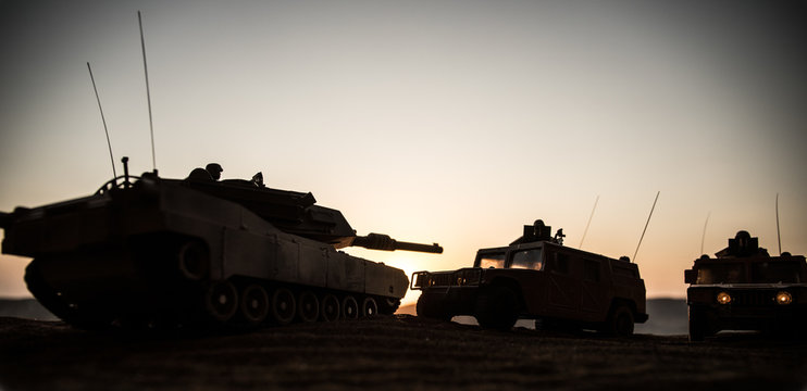 Military patrol car on sunset background. Army war concept. Silhouette of armored vehicle with soldiers ready to attack. Artwork decoration. Selective focus