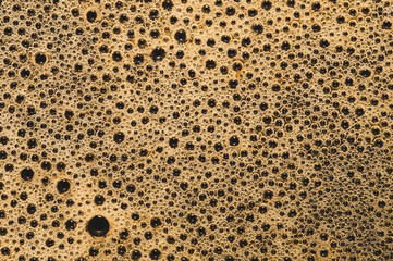 Coffee foam with bubbles macro texture. froth drink