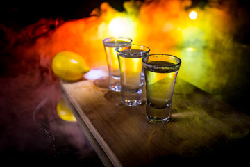 Club drink concept. Tasty alcohol drink cocktail tequila with lime and salt on vibrant dark background or glasses with tequila at a bar