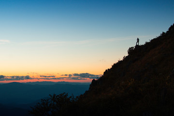 Man hikers standing on mountain cliff silhouette 