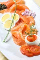 Salmon salad served on white plate, top view.