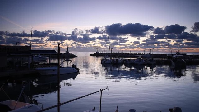 Beautiful sunrise over the calm water of Cala Bona Marina.