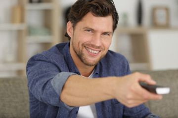 smiling man holding remote control