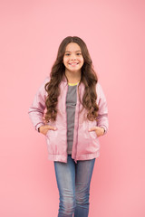 In traditional autumn style. Happy small girl enjoy comfortable fashion style. Little cute child with long brunette hair style smile on pink background. Her style is a lot more casual