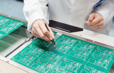 Technician assembling electronic product by inserting components into board