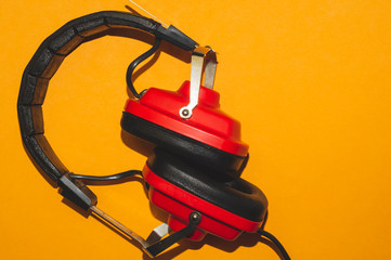 Vintage red headphones on yellow background. classic earphones