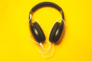 Fototapeta na wymiar Headphones with white cable on a yellow background