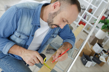 man holding a measure tape at home