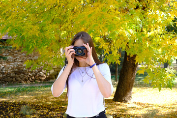 girl with camera in the park in autumn