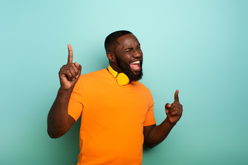 Boy with yellow headset listens to music and dances. emotional and energetic expression