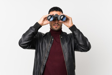 Young man over isolated white background with black binoculars