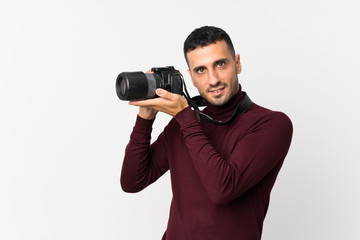 Young man over isolated white background with a professional camera