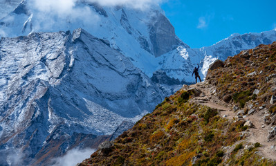 Active hiker hiking, enjoying the view  at Himalaya mountains and Mount Ama Dablam landscape. Travel sport lifestyle concept
