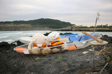 Two toy bears in life vests in a boat on one of the beaches on Jeju Island, South Korea
