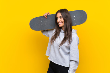 Young skater woman over isolated yellow background