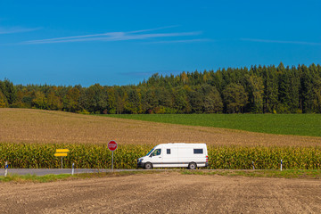 Delivery van traveling in the countryside. White transporter driving on a rural road at summer...