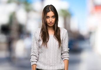 Young hispanic brunette woman with sad and depressed expression at outdoors