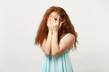 Young pretty redhead woman in casual light clothes posing isolated on white wall background. People sincere emotions lifestyle concept. Mock up copy space. Covering face with hands, hiding, peeping.