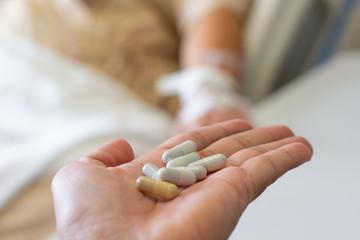 Medicine in hand on blurred a patient sleeping the bed in room,