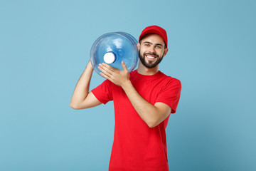 Delivery man in red uniform cap t-shirt print workwear carrying bottle of water to office cooler isolated on blue background studio portrait. Male employee courier. Service concept. Mock up copy space