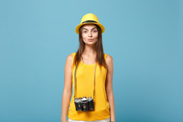 Traveler tourist woman in yellow summer casual clothes, hat with photo camera isolated on blue background. Female passenger traveling abroad to travel on weekends getaway. Air flight journey concept.