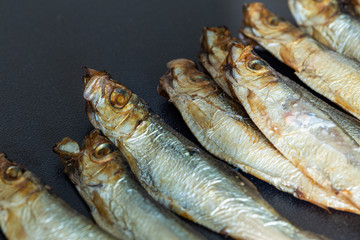 Smoked sprats on a dark background