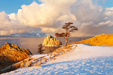 Baikal Lake in December. Magnificent sunset landscape of Olkhon Island in cloudy and snowy weather....